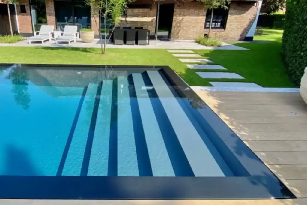 Resort-Style-Pool von der Seite gesehen mit einer Einstiegstreppe, die über die ganze Breite geht.