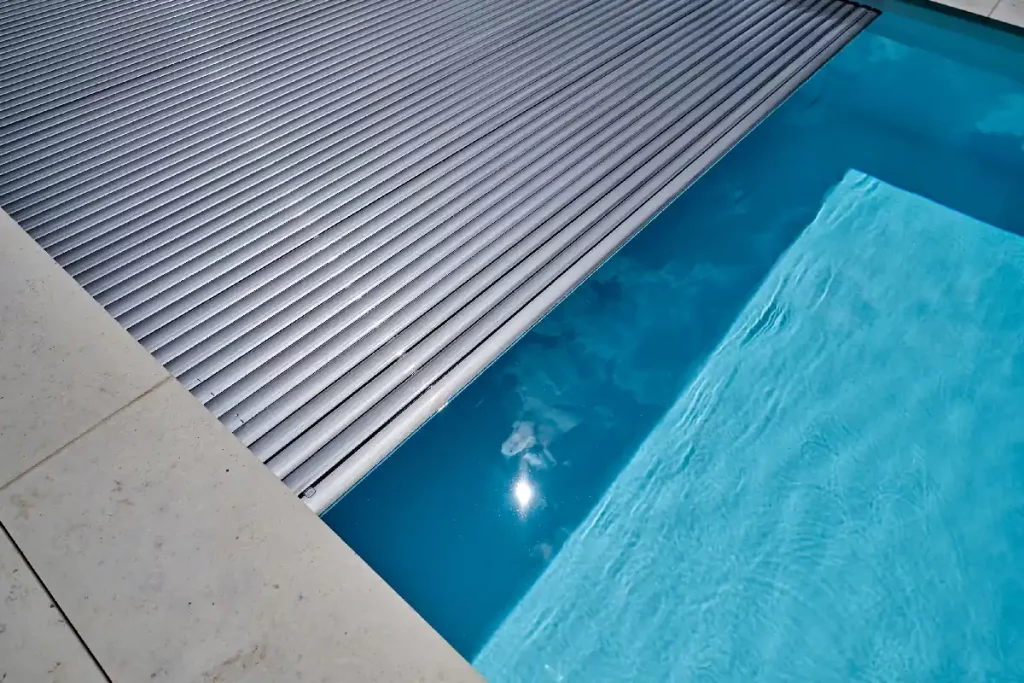 Großer Pool mit halb eingefahrenem Poolrollo